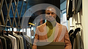 Handsome black man walking with shoe boxes in clothing store. A man buying shoes in the store