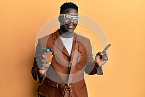 Handsome black man wearing business bag and drinking coffee smiling happy pointing with hand and finger to the side