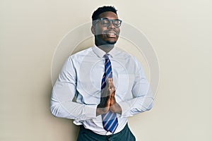 Handsome black man wearing glasses business shirt and tie begging and praying with hands together with hope expression on face
