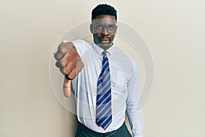 Handsome black man wearing glasses business shirt and tie looking unhappy and angry showing rejection and negative with thumbs