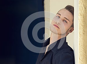 Handsome blond young man against wall