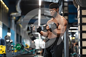 Handsome bodybuilder making work out with barbells at gym