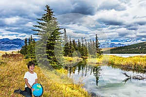 Handsome boy with a globe laughs