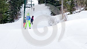 Handsome boy go up on t-bar ski lift at alpine resort