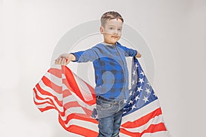 Handsome boy holding american flag and celebrating July 4th. Cute boy looking at camera. Closeup of happy boy with