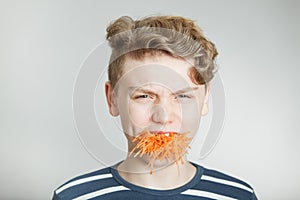 Handsome boy with a mouthful of grated carrot photo
