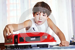 Handsome boy play with meccano toy train