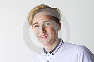 Handsome boy teenager in white shirt smiles