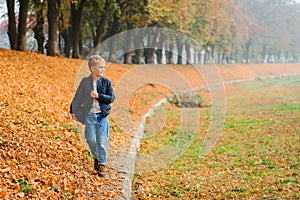 Handsome boy walking autumn park. Autumn fashion. Happy autumn holidays. Stylish kid in autumn