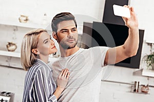 Handsome boyfriend and attractive girlfriend taking selfie