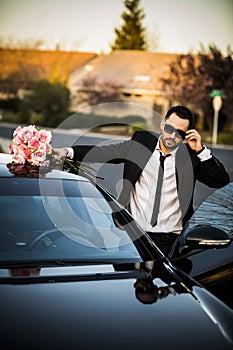 Handsome boyfriend in black suit waiting his girlfriend on street.