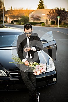 Handsome boyfriend in black suit waiting his girlfriend on street.