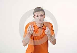 Handsome brown-haired man wearing orange shirt looking angry showing hand gesture and talking something irate over white