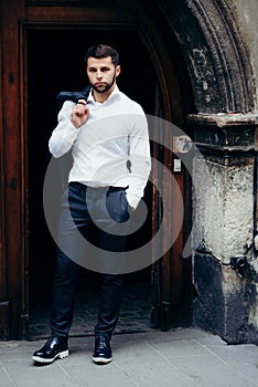 Handsome brunet groom. Outdoor wedding portrait. Full-length shot.