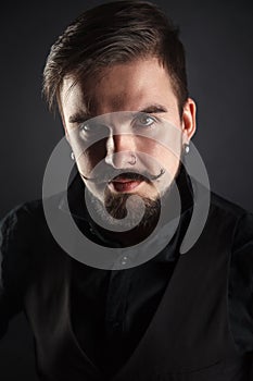 Handsome brutal guy with beard on dark background