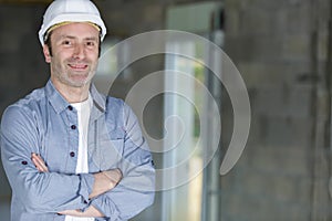 handsome builder posing with armscrossed photo