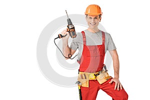 Handsome builder in uniform with tool belt holding drill