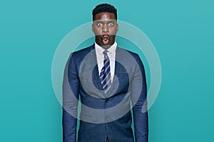 Handsome business black man wearing business suit and tie afraid and shocked with surprise expression, fear and excited face
