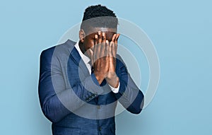 Handsome business black man wearing business suit and tie with sad expression covering face with hands while crying
