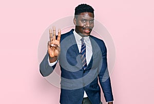 Handsome business black man wearing business suit and tie showing and pointing up with fingers number three while smiling