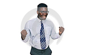 Handsome business black man wearing white shirt and tie screaming proud, celebrating victory and success very excited with raised