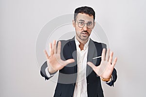 Handsome business hispanic man standing over white background afraid and terrified with fear expression stop gesture with hands,