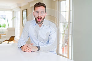 Handsome business man afraid and shocked with surprise expression, fear and excited face