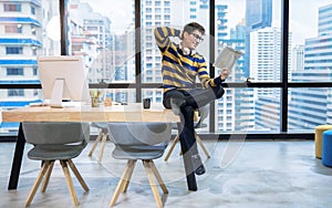 A handsome business man in casual clothes, sitting and reading his business documents happily