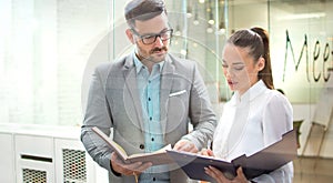 Handsome business man checking paper documents with female partner at meeting point room.