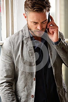 Handsome business man having serious telephone conversation