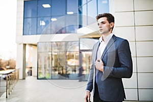 Handsome business man outdoors in front of office building