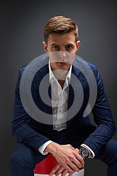 Handsome business man owner of oil company sit on barrel posing