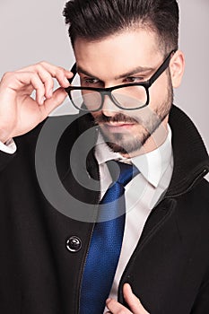 Handsome business man putting on his glasses