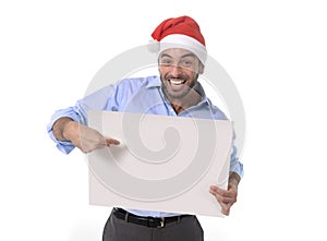 Handsome business man in santa christmas hat pointing blank billboard