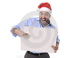 Handsome business man in santa christmas hat pointing blank billboard