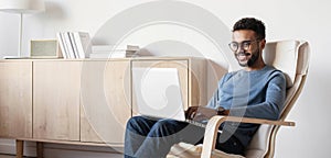 Handsome business man using laptop computer at home panoramic banner. Student men working or learning online in his room.
