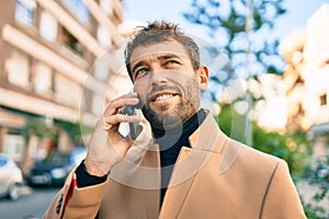 Handsome business man wearing elegant jacket using smartphone smiling happy outdoors