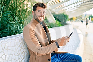 Handsome business man wearing elegant jacket using smartphone smiling happy outdoors