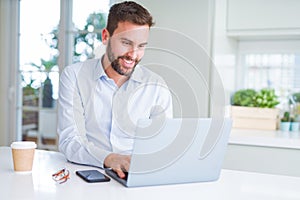 Handsome business man working using computer laptop and smiling