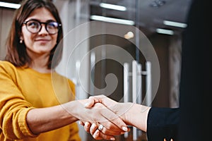 Handsome business woman handshaking after succsessful deal. Positive working moment