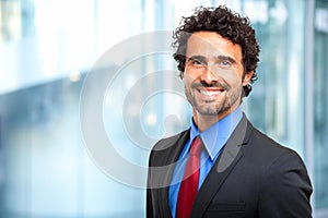 Handsome businessman against blurry background