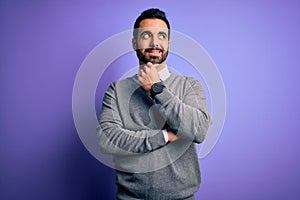 Handsome businessman with beard wearing casual tie standing over purple background with hand on chin thinking about question,