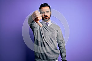 Handsome businessman with beard wearing casual tie standing over purple background looking unhappy and angry showing rejection and