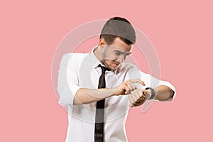 Handsome businessman checking his wrist-watch Isolated on pink background