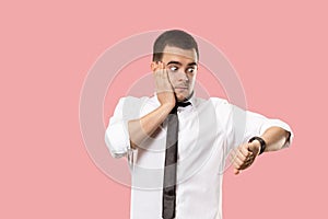 Handsome businessman checking his wrist-watch Isolated on pink background