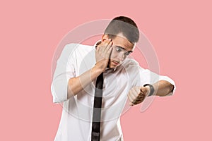 Handsome businessman checking his wrist-watch Isolated on pink background