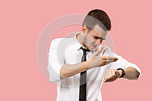 Handsome businessman checking his wrist-watch Isolated on pink background