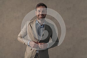 Handsome businessman closing his suit and giving a big smile