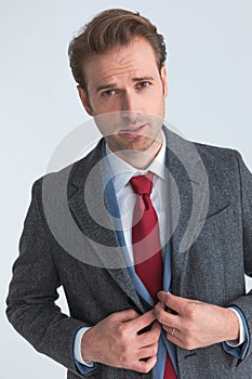 Handsome businessman closing his suit, wearing a coat