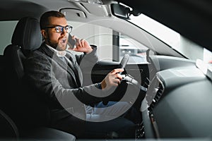 Handsome businessman driving car to airport, going on business side view, copy space. Happy man in stylish suit going to
